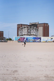A dynamic beach sprint race in Brazil with athletes sprinting on golden sand under a bright blue sky.