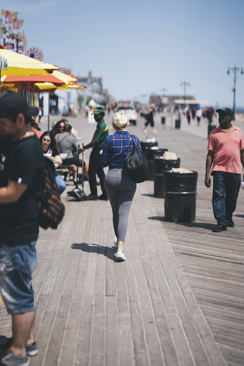 woman walking along sidewalk ]