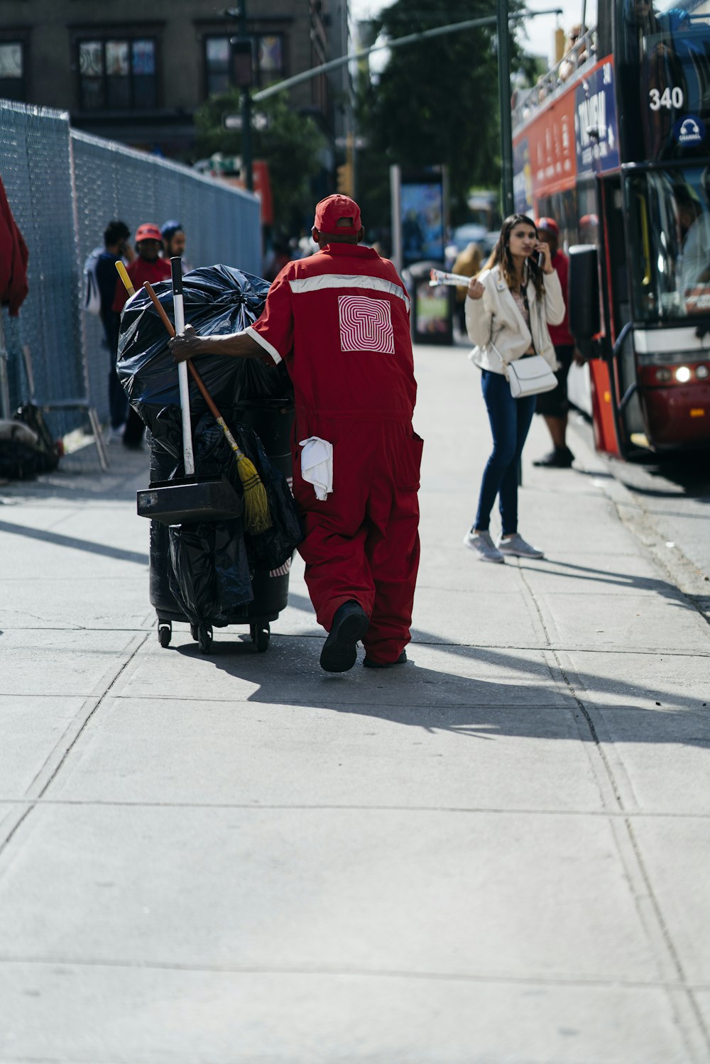 a man in a red suit pulling a cart down a street