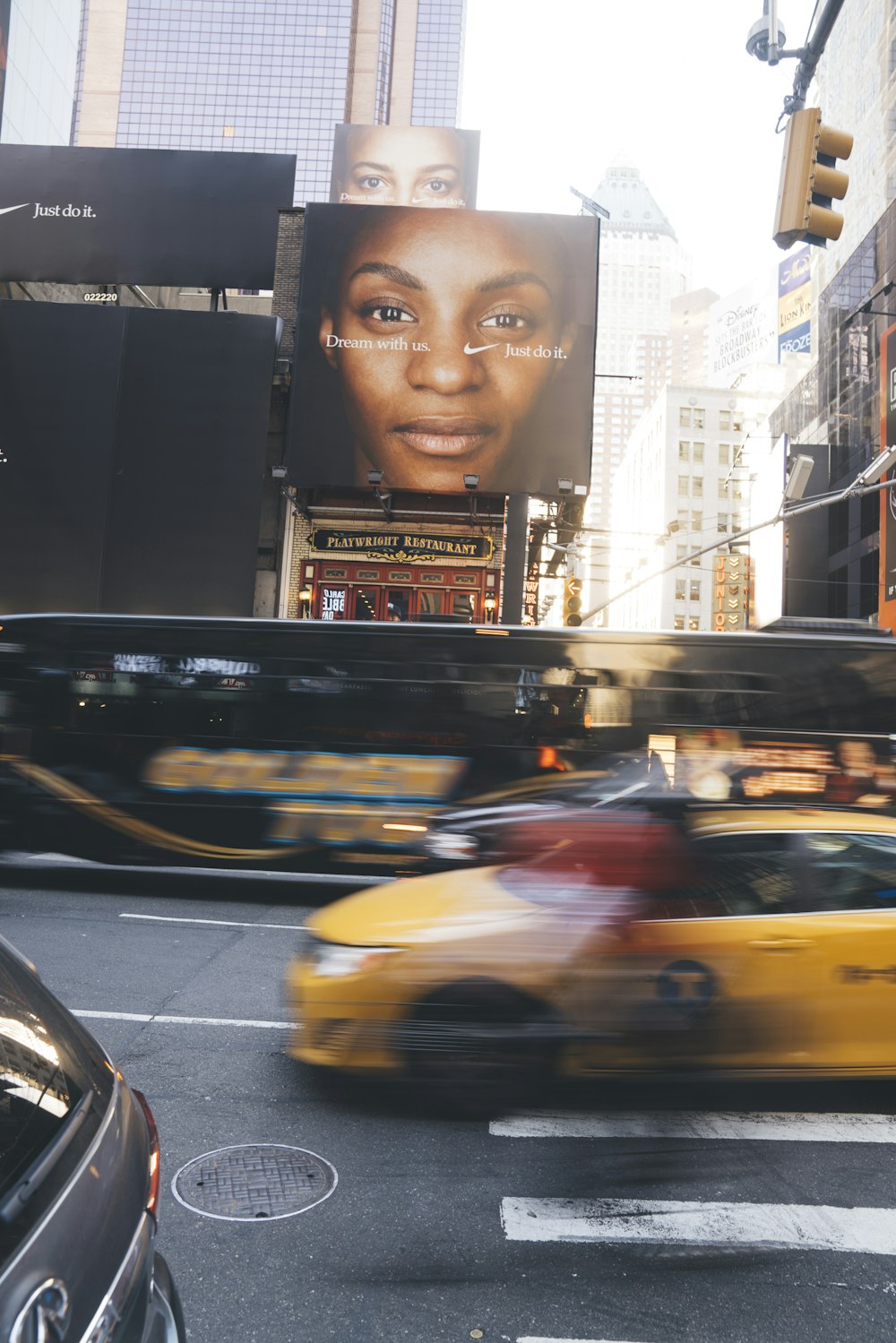 different vehicles on road near buildings with billboards during daytime