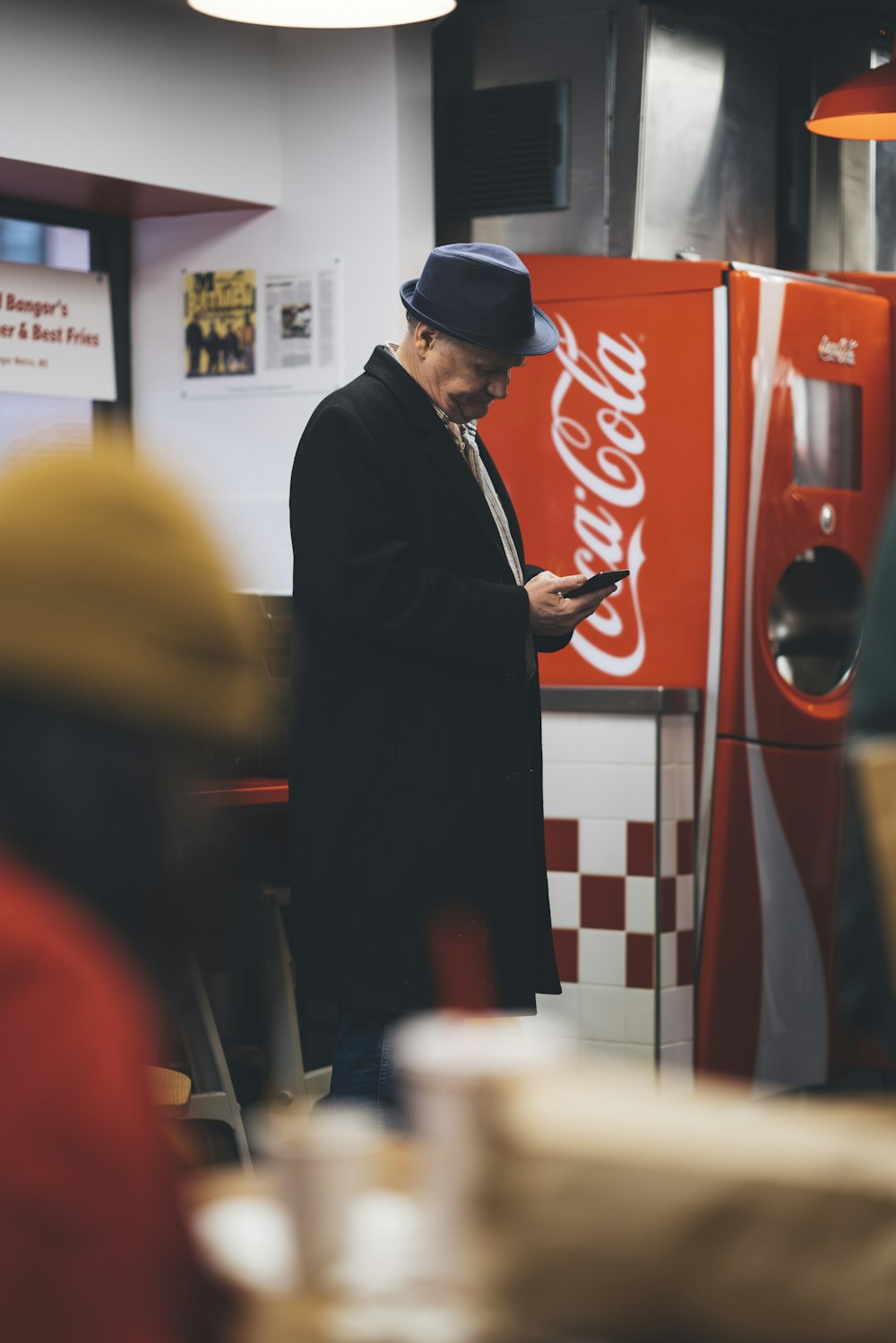 man in black coat holding his phone