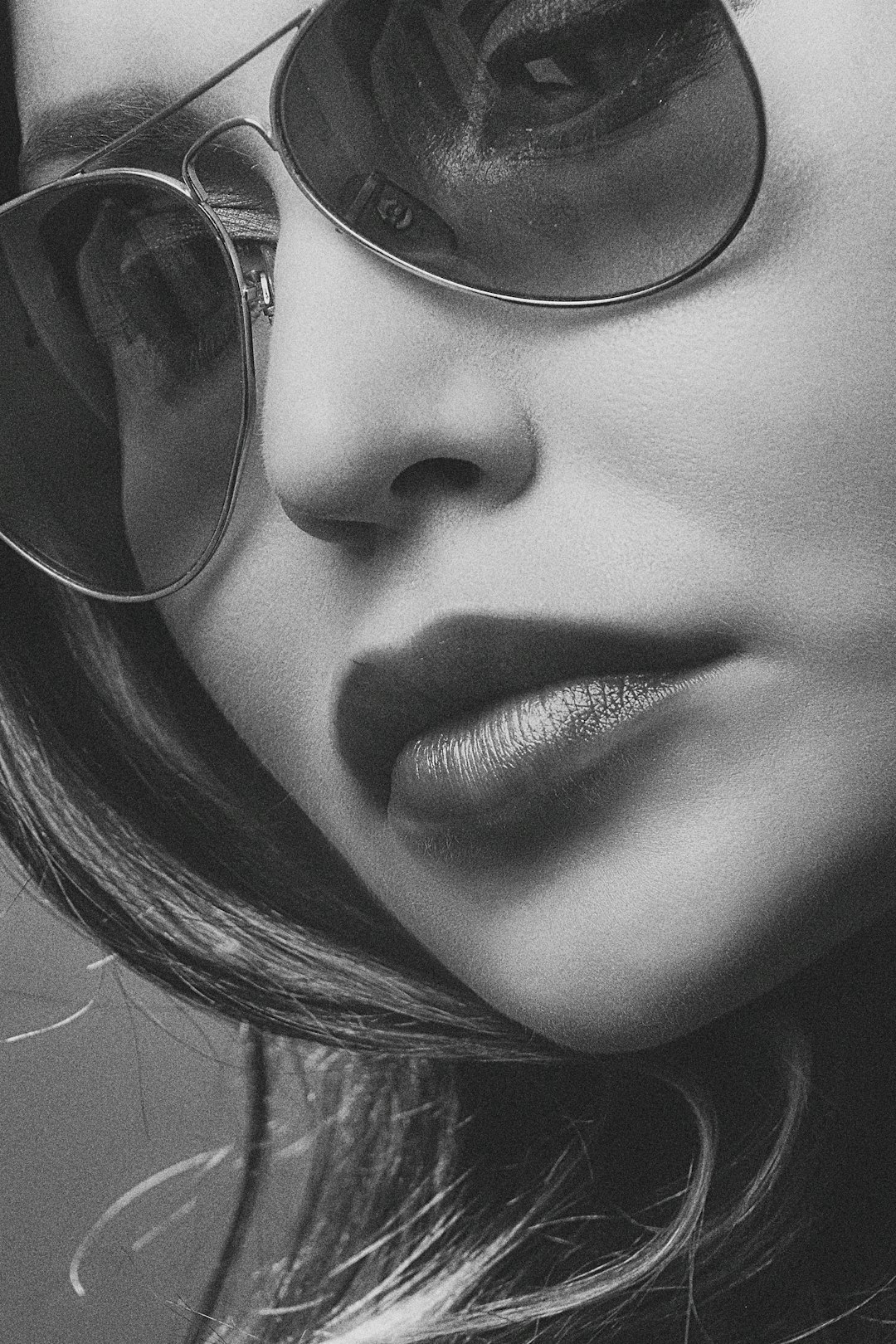 grayscale photo of a woman wearing aviator sunglasses