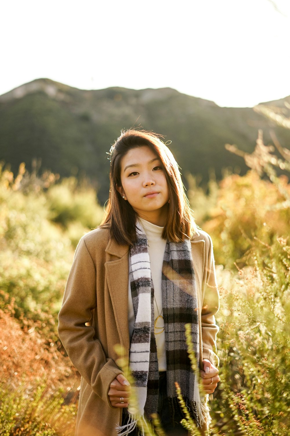 selective focus photography of standing woman surrounded by plants