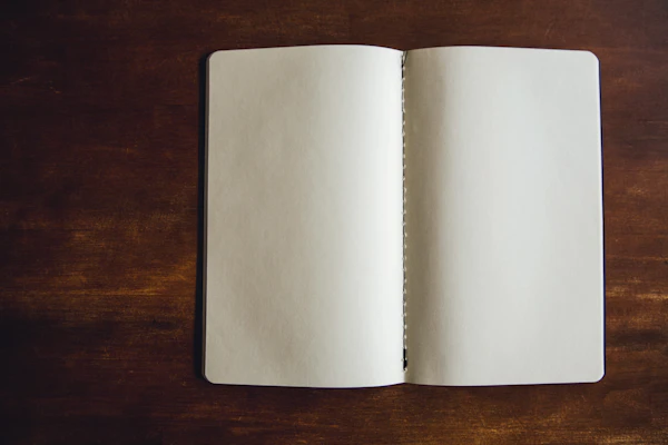 白い未記入のノートが広げられた写真。「やりたいことが書き出せていない」状態を象徴するイメージ