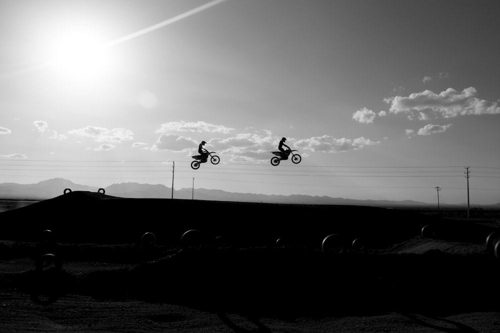 two silhouette of man riding motorcycle