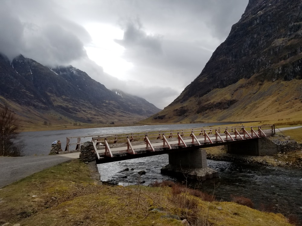 gray bridge viewing mountain under white and gray sky