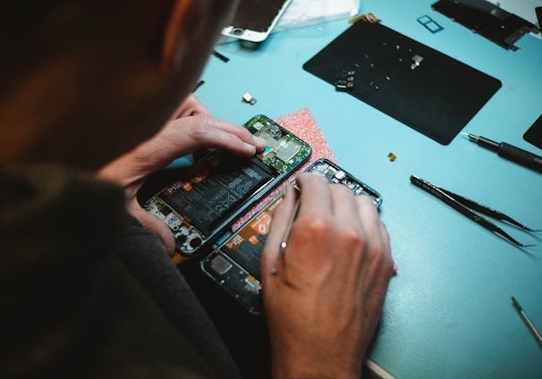 person repairing smartphones under a lighted table