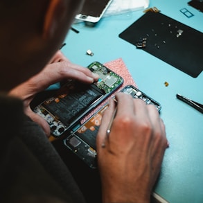 person repairing smartphones under a lighted table