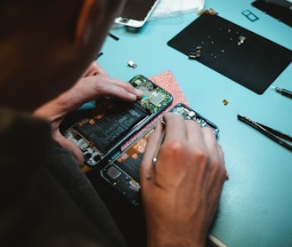 person repairing smartphones under a lighted table