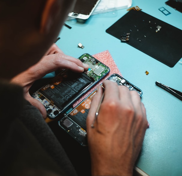 person repairing smartphones under a lighted table