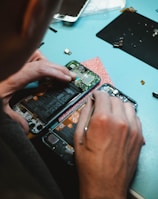 person repairing smartphones under a lighted table