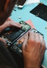 person repairing smartphones under a lighted table