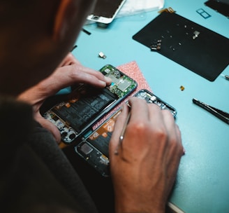 person repairing smartphones under a lighted table