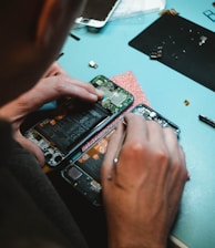 person repairing smartphones under a lighted table