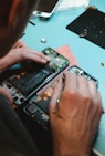 person repairing smartphones under a lighted table