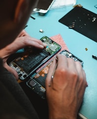 person repairing smartphones under a lighted table