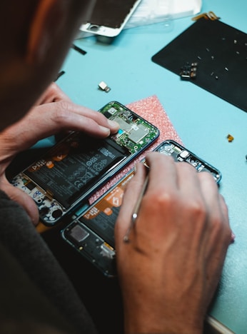 person repairing smartphones under a lighted table