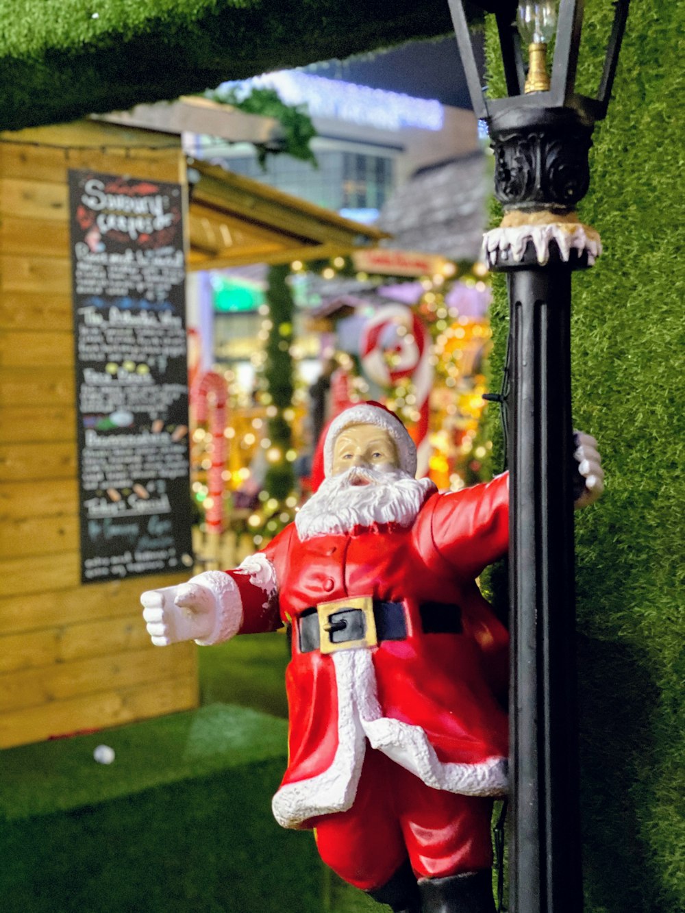 Santa Claus holding lamp post figurine