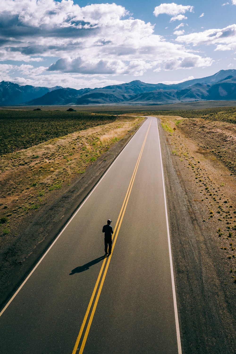 person standing on empty road at daytime