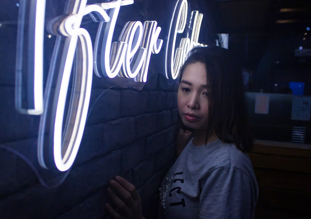woman standing in front of neon light signage