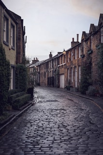 Golden hour light bathes a quiet cobblestone street in a historic London neighborhood, framed by elegant townhouses.