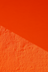 an orange wall with a shadow on it