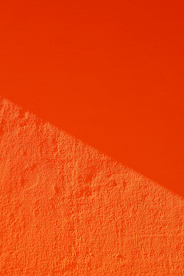 an orange wall with a shadow on it