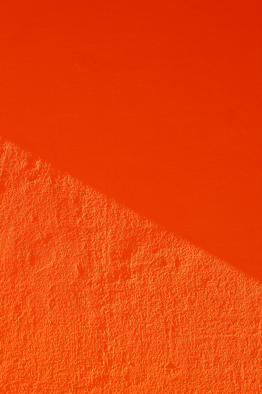 an orange wall with a shadow on it