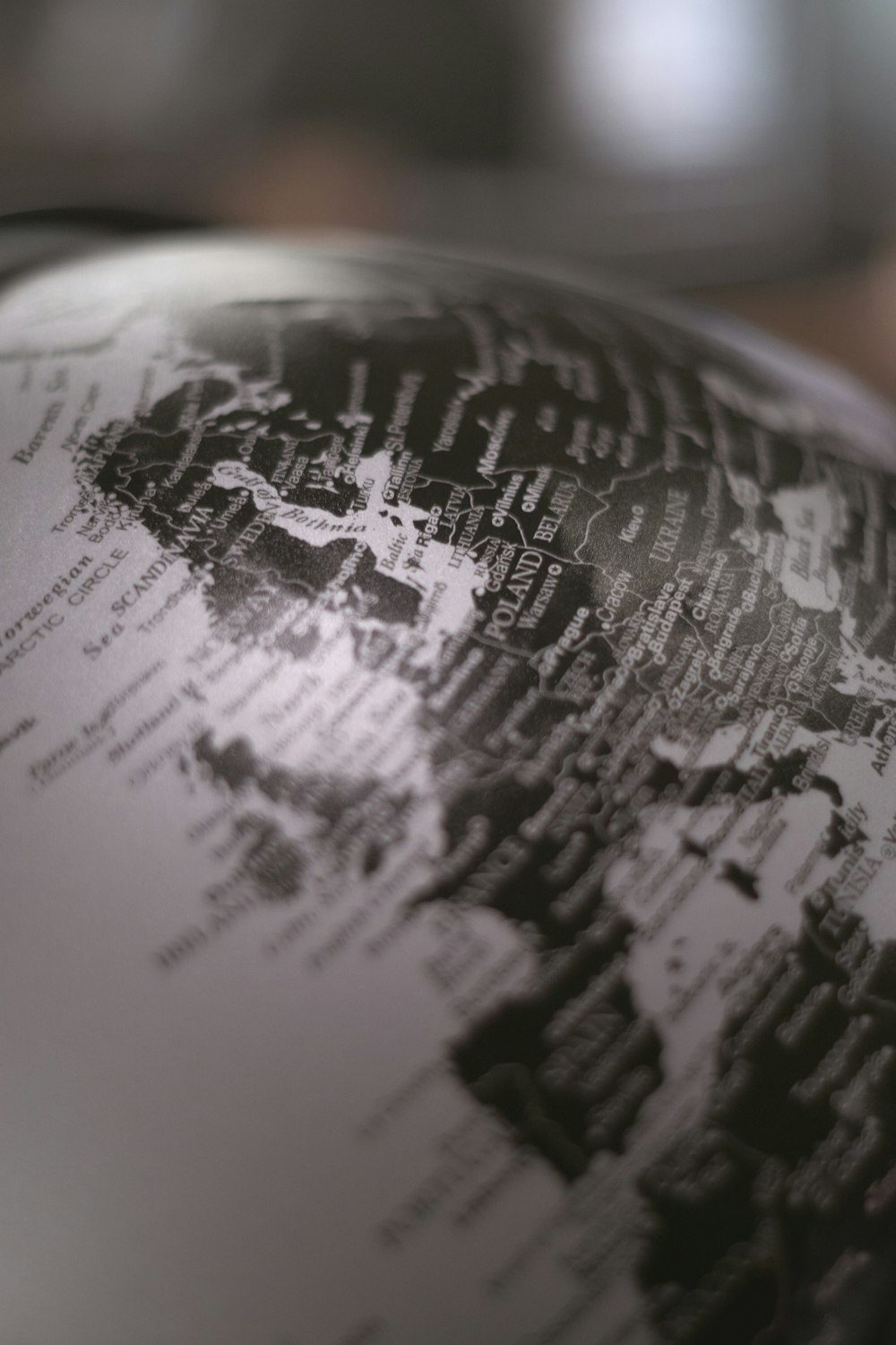 grayscale and selective focus photography of table globe