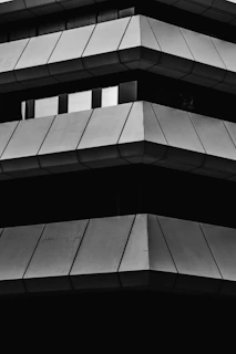 A sleek black and white photo of the engineering house office building exterior at dusk, showcasing clean lines and modern architecture.