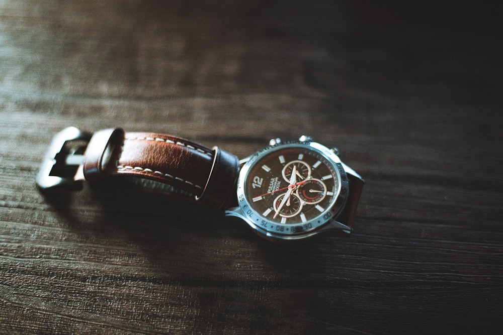 a watch sitting on top of a wooden table