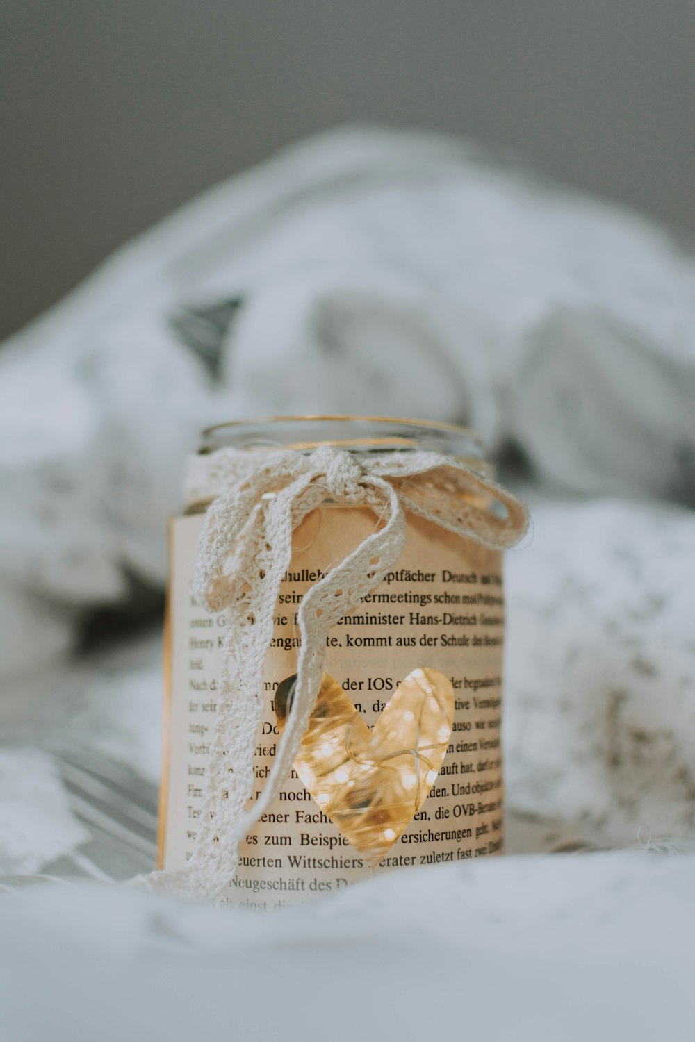 a jar of honey sitting on top of a bed