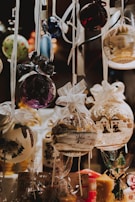 A collection of delicate resin holiday ornaments hanging on a rustic wooden branch.