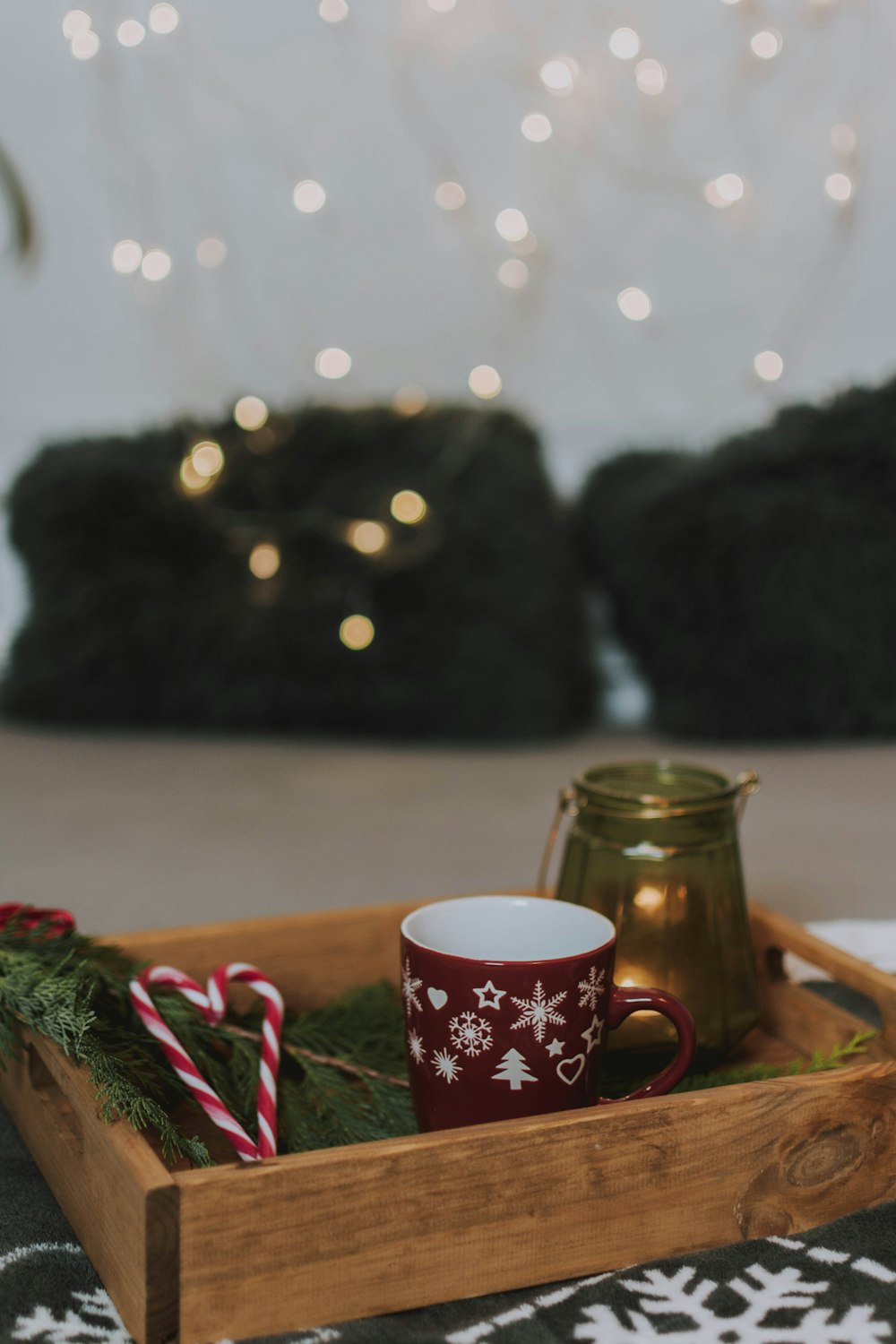 candy canes on wooden crate near red and white ceramic mug