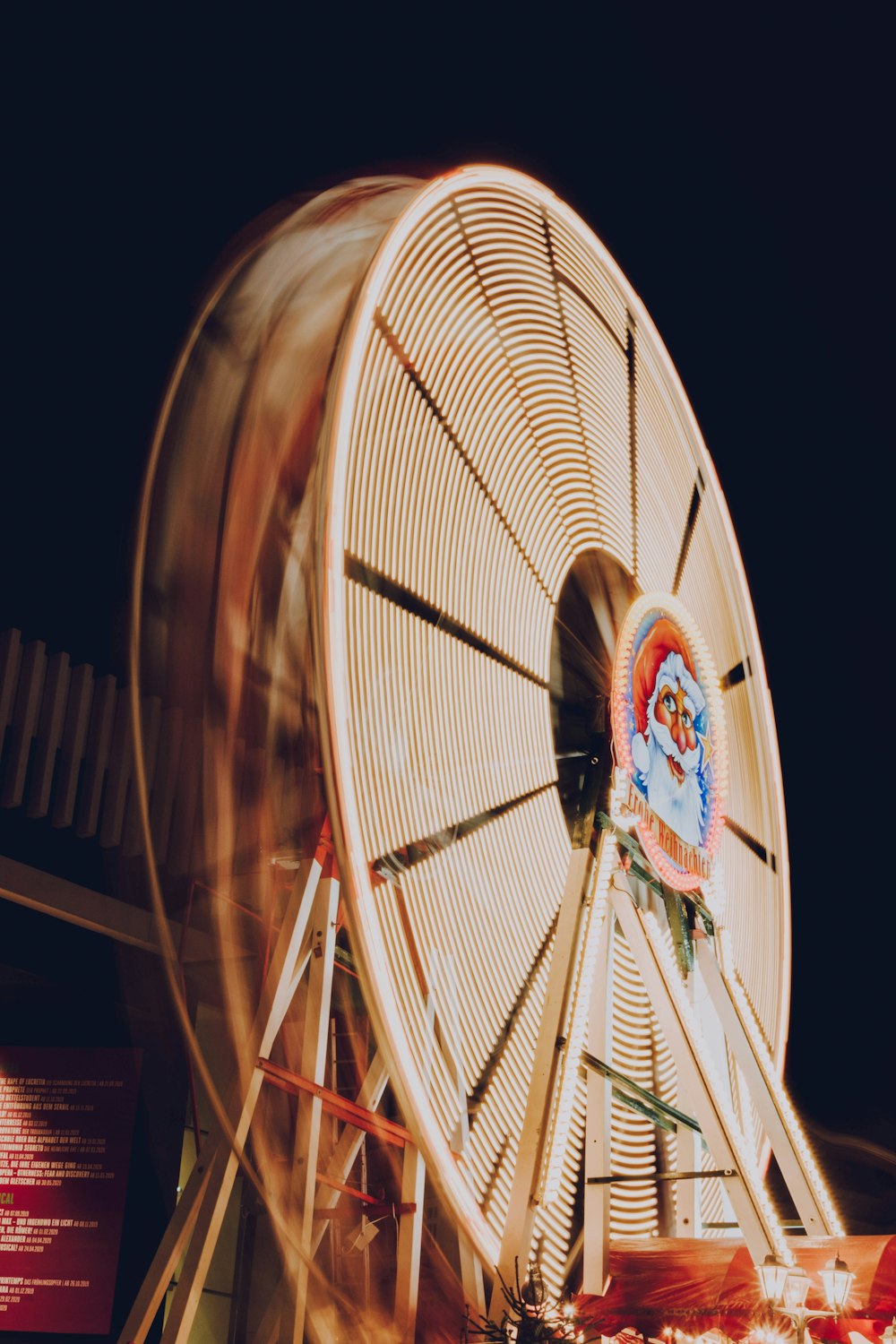 a ferris wheel spinning in the dark at a carnival