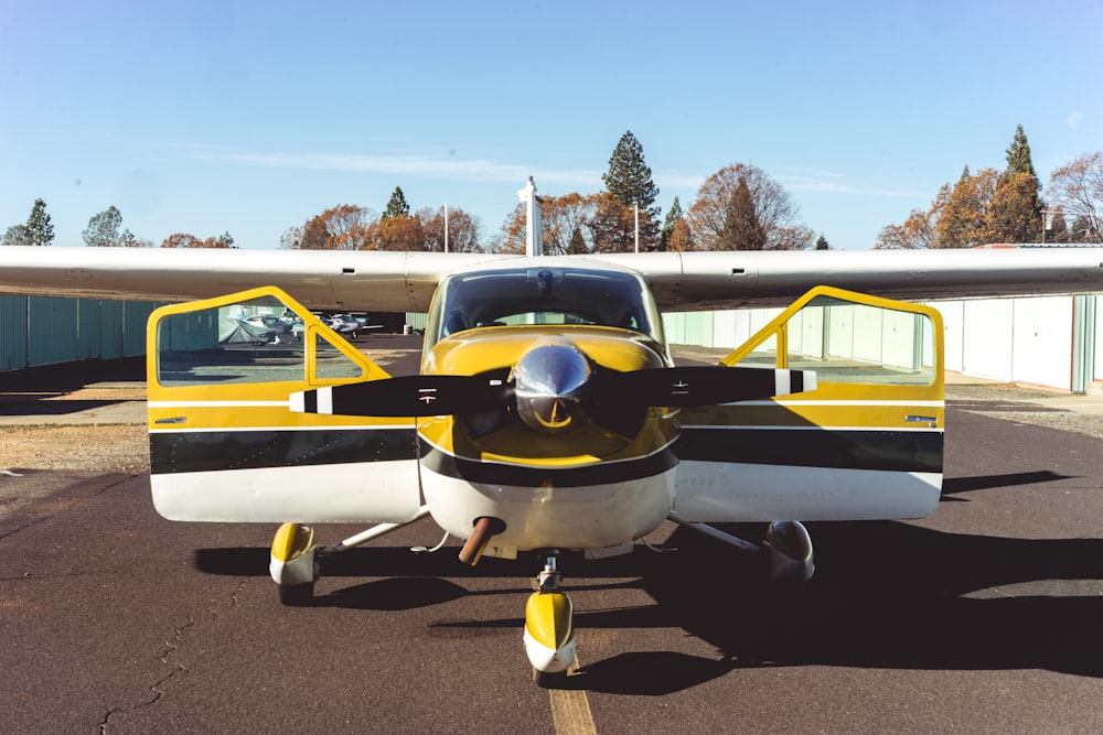 monoplane with with open doors by buildings at tarmac during daytime