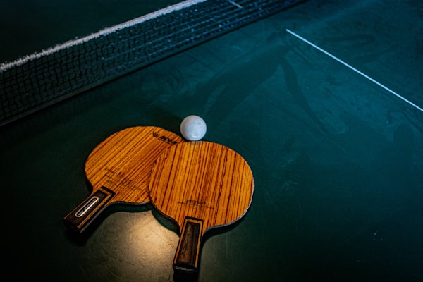 Two table tennis bats lying on a table 