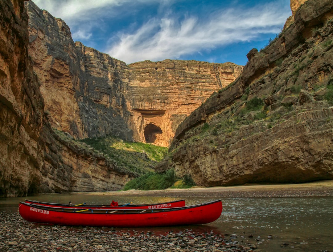 red canoe on soil with view of mountains during daytime