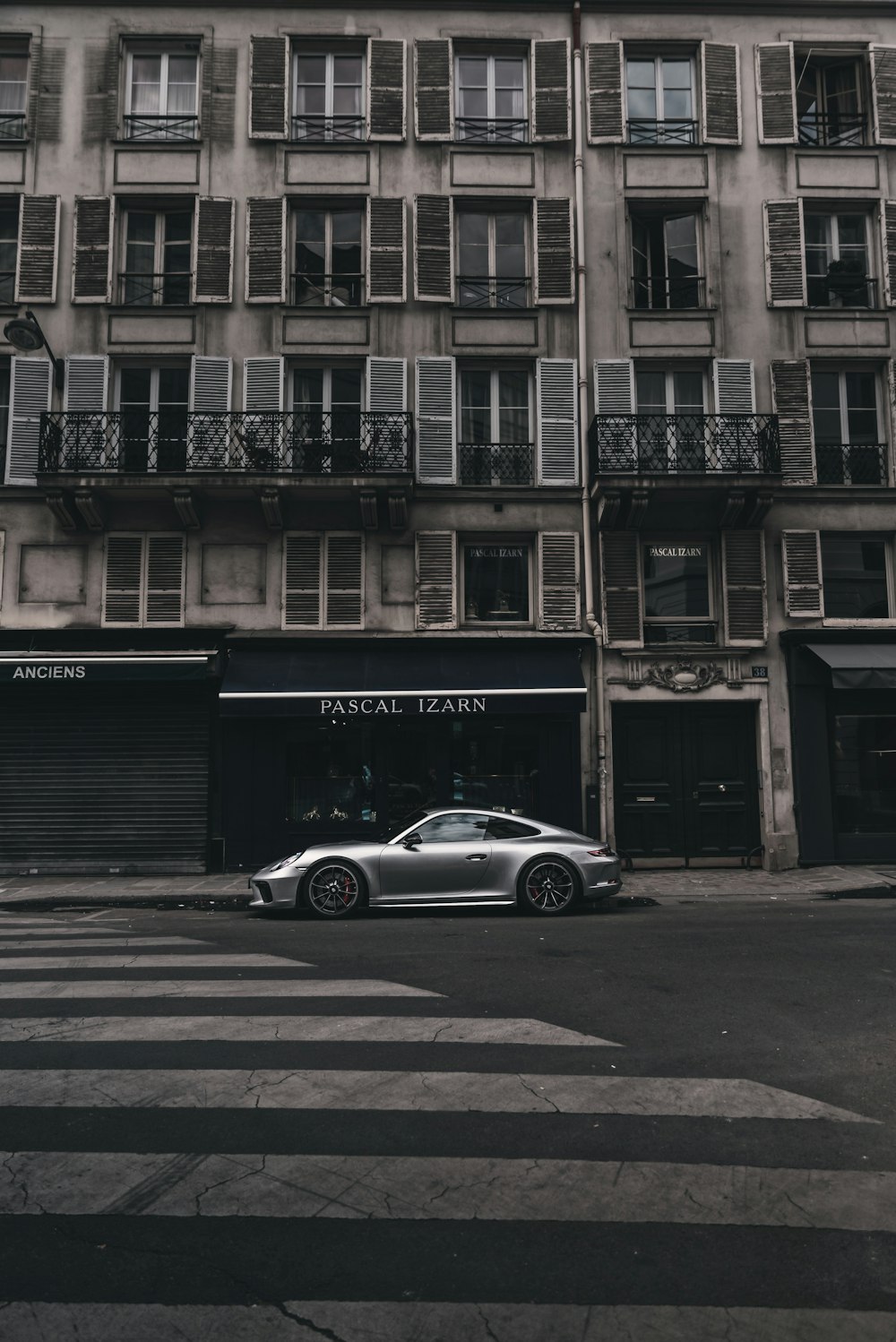 silver coupe parked beside building