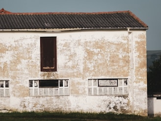 Exterior façade being coated with cement plaster under bright daylight.