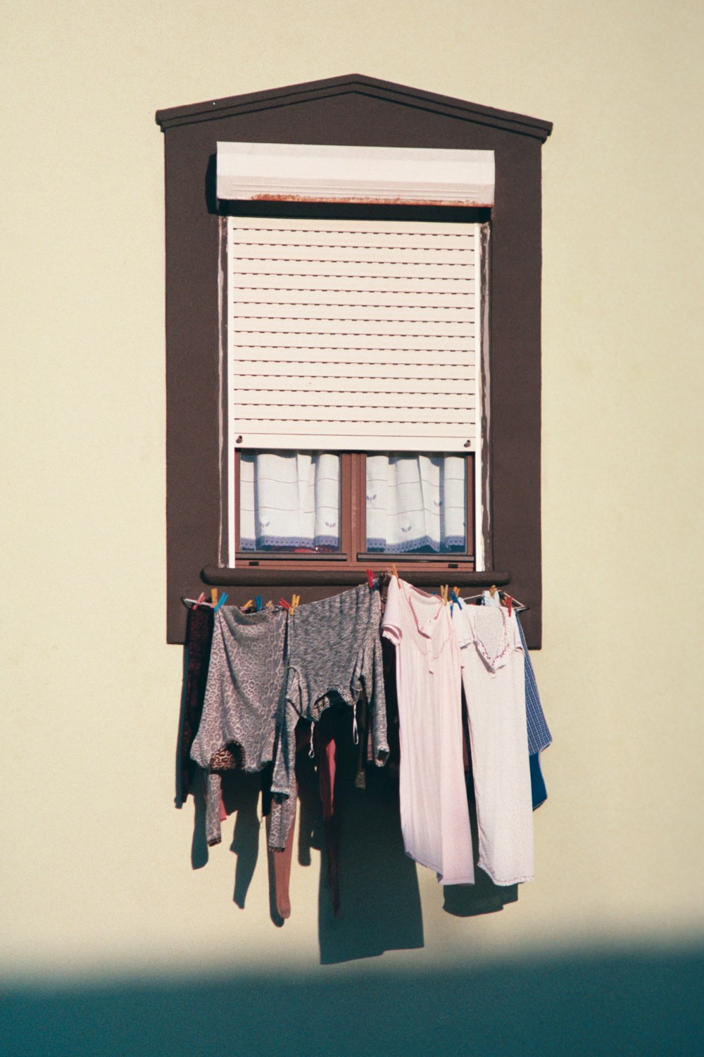 shallow focus photo of clothes hanging on brown wooden window