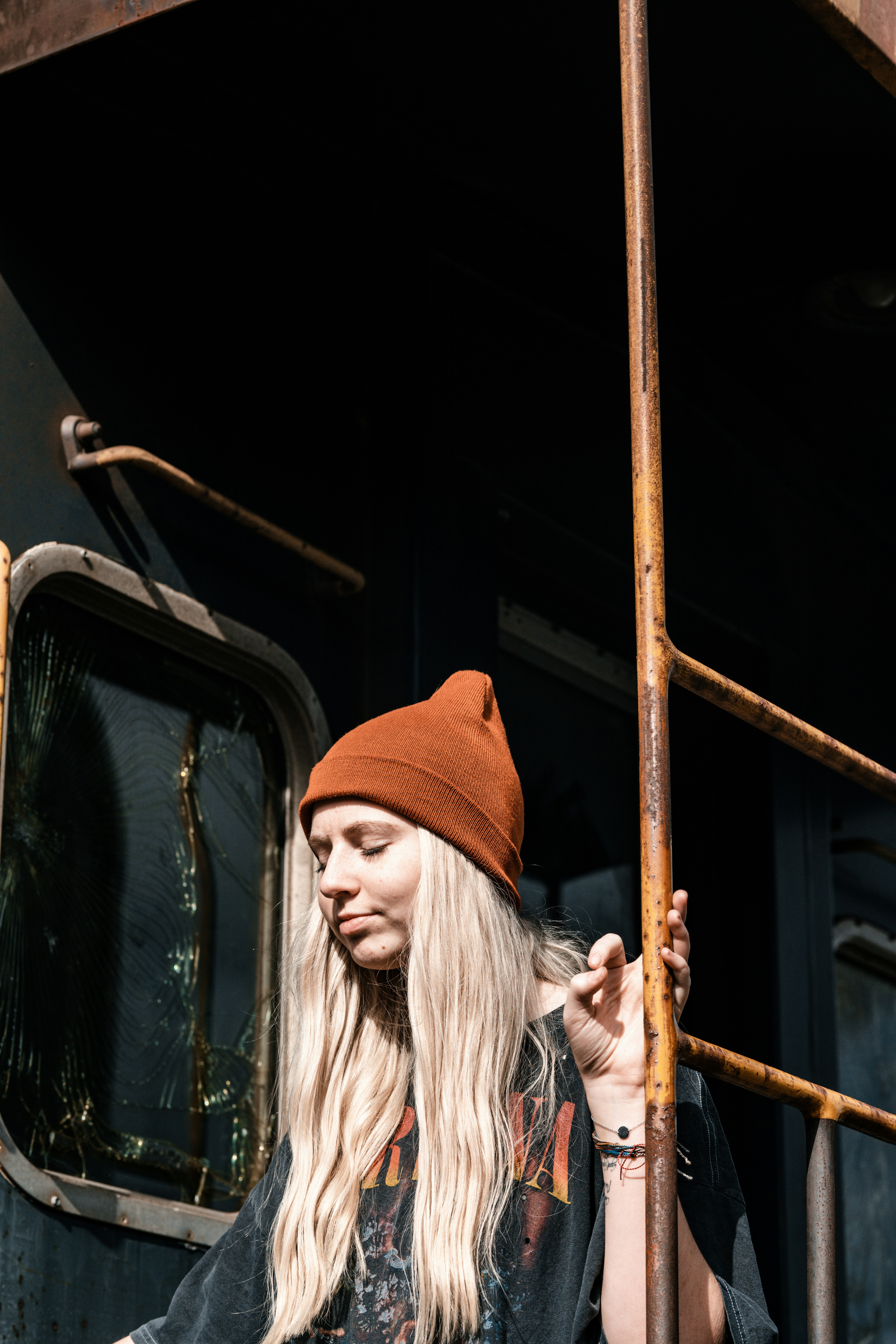 a woman with long blonde hair standing on a train