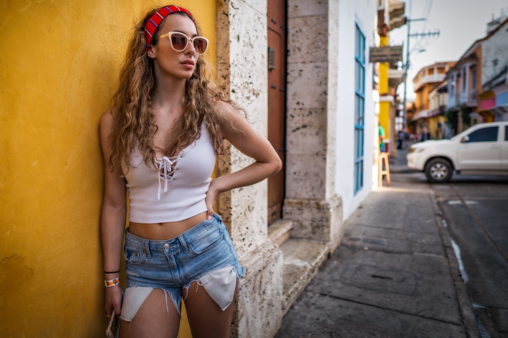 woman standing beside wall near car