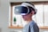 Young man wearing VR headset, visibly engaged and amazed by the virtual world around him.