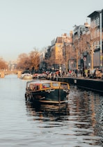 black and yellow boat in body of water in front of buildings