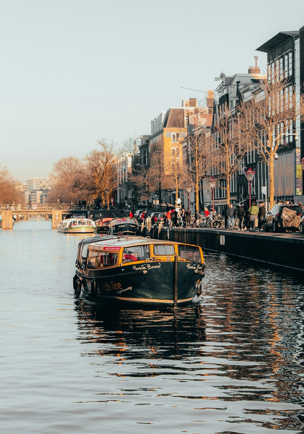 black and yellow boat in body of water in front of buildings