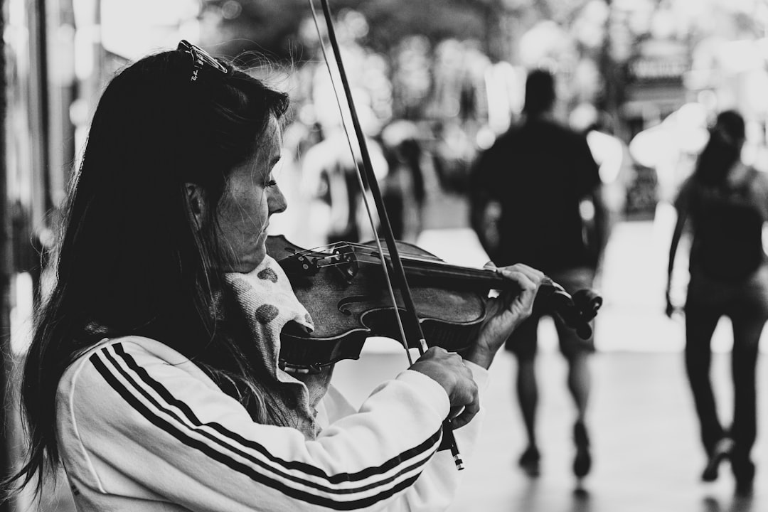woman using violin grayscale photo