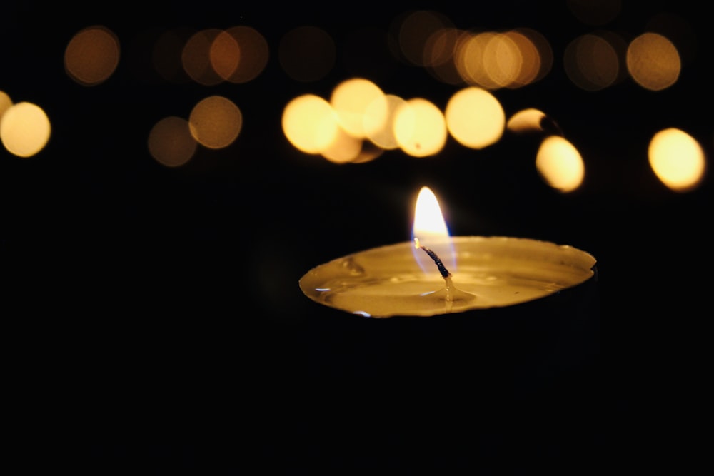 shallow focus photography of lit votive candle