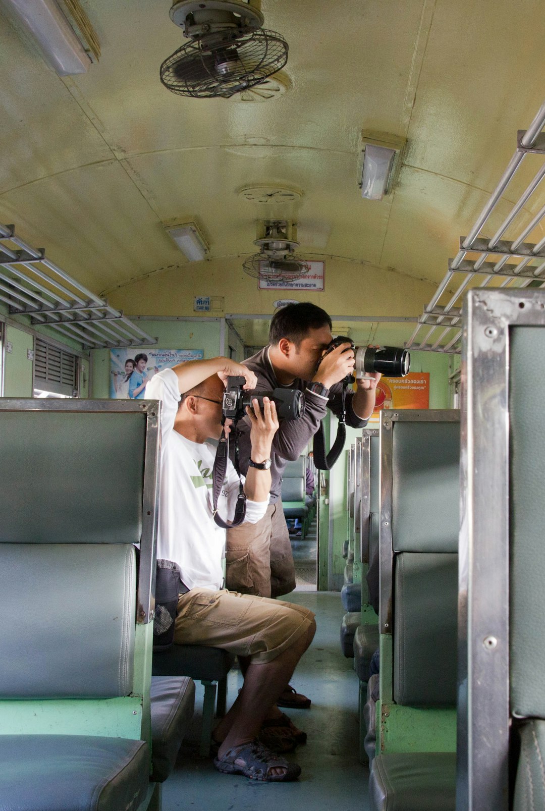 men with DSLR cameras in train