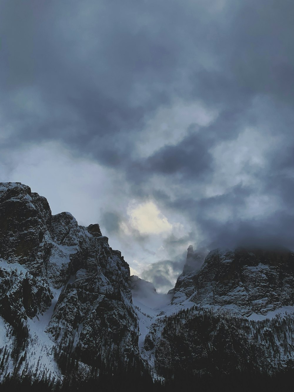 snow covered mountain under cloudy sky